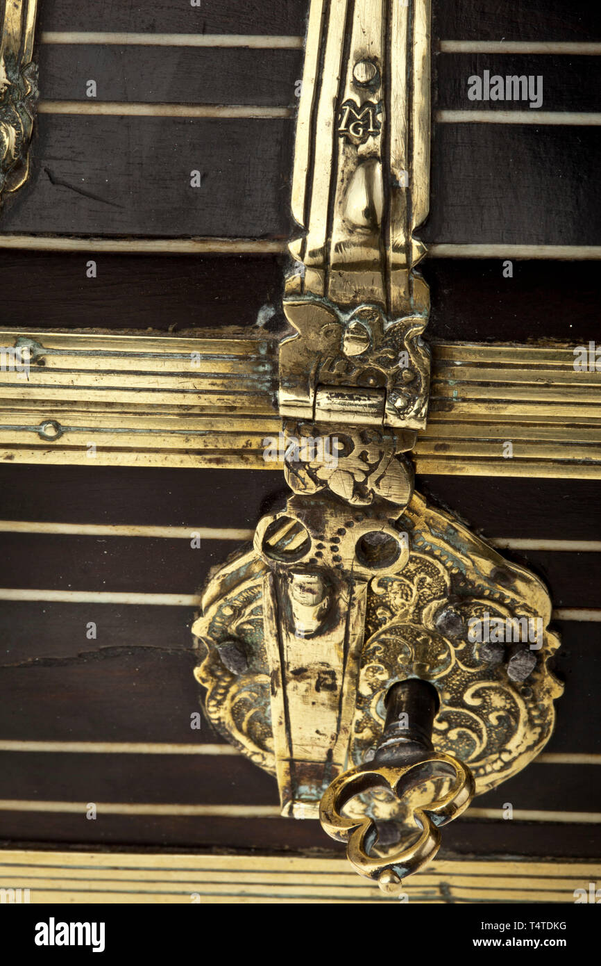 Uno scrigno con un coperchio a cupola, Norimberga, circa 1620, il corpo rettangolare realizzata in legno di quercia, con un coperchio arrotondato. I lati e il coperchio interamente impiallacciato in ebano, intervallati con ornamenti di osso. La cerniera e le cinghie di rinforzo del bordo finemente lavorato in ottone, centro cinghia a cerniera contrassegnato 'MG'. La serratura sul lato anteriore con una cerniera a occhiello e la piastra di bloccaggio con una decorazione viticci. Originale di gambo cavo chiave con arco in ottone. Il coperchio con un coperchio bloccabile cassetto. Una calcografia etichetta recante il marchio del fabbricante 'Michael Iennig a Nurnberg' incollato all'interno di t, Additional-Rights-Clearance-Info-Not-Available Foto Stock