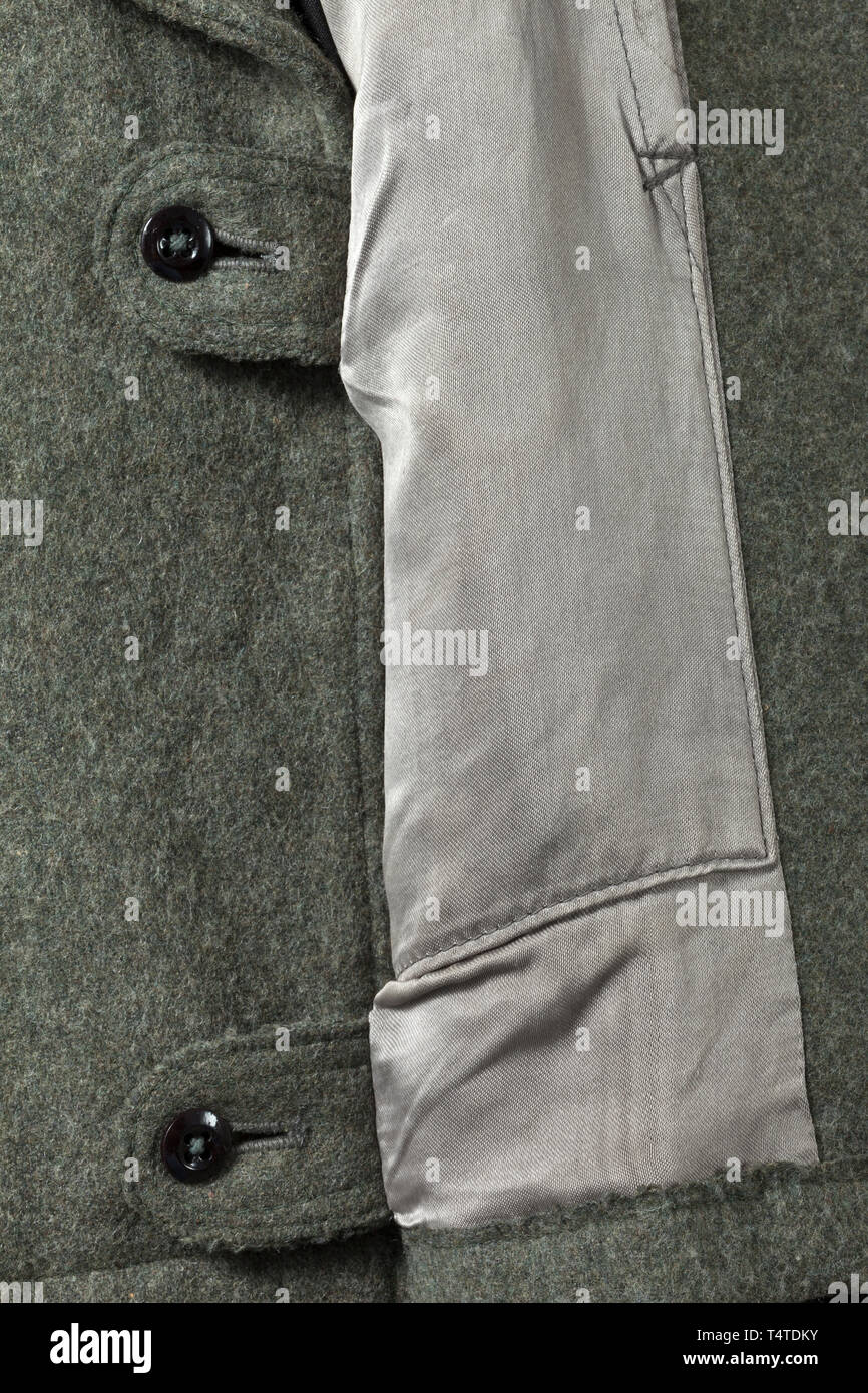 Una tunica di campo del campo-grigio uniforme speciale per un membro dell'Assalto unità di pistola della 5SS Panzer Division " WIKING", SS tagliato con pulsante rettilineo vola e un pezzo di schienale realizzato in campo grigio in panno di lana con una resina sintetica pulsanti. Rivestimento parziale in acciaio-grigio seta artificiale con deposito- e la dimensione dei timbri. BeVo nero collare tessuto patch, nero slittamento su schede di spalla con tubazioni di rosso. RZM manicotto ricamato eagle su fondo nero, al di sotto di esso il manicotto banda "Wiking' in RZM macchina-versione ricamata per uomini arruolati. Molto rare, appena indossato tunica. Xx secolo, 1930, Editorial-Use-solo Foto Stock