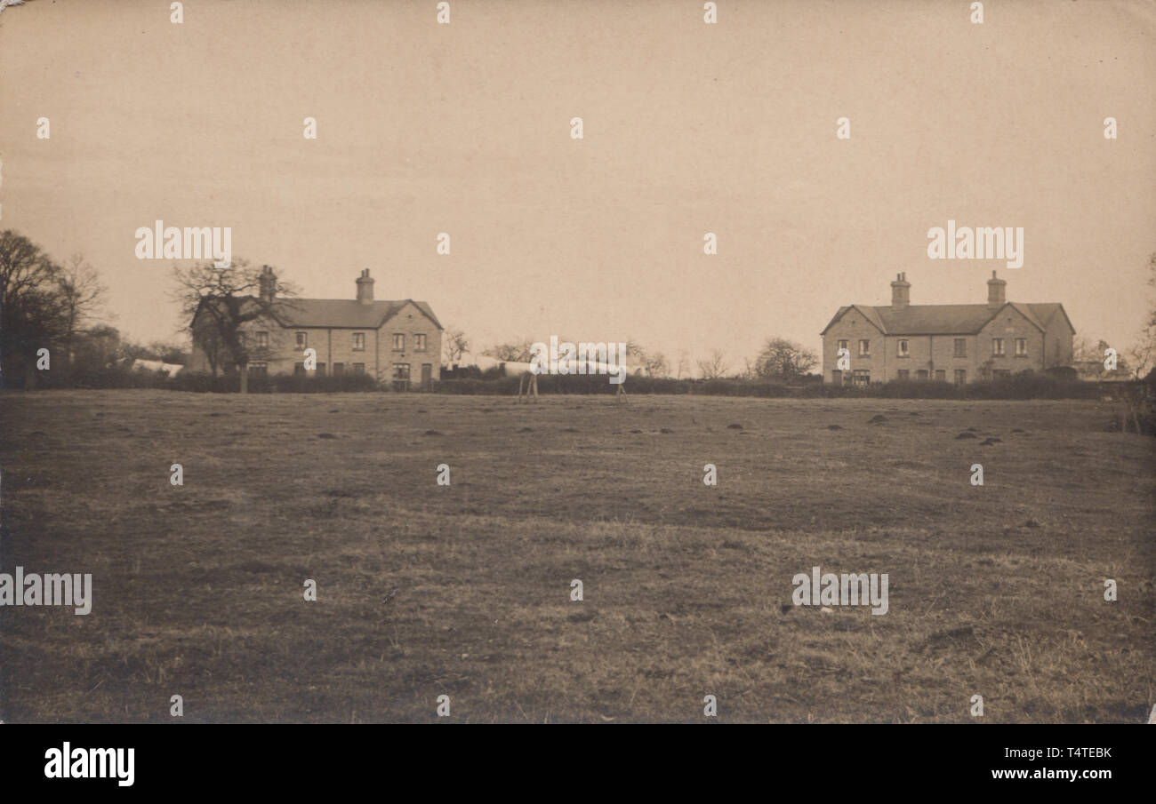 Vintage British Cartolina fotografica che mostra Terra comune e alcune case con le loro linee di lavaggio nella distanza Foto Stock