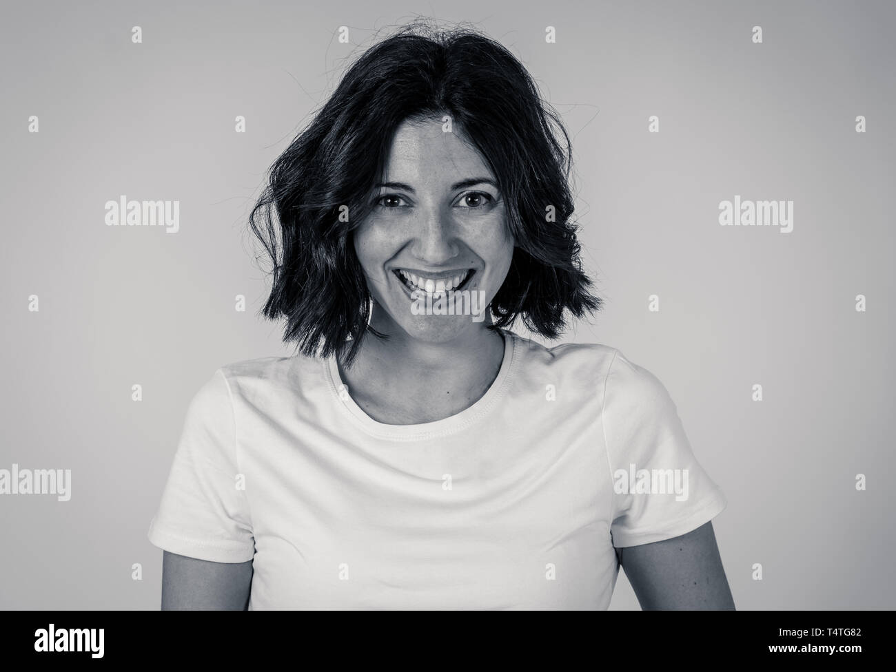 Bianco e nero ritratto di giovane bella donna caucasica con la faccia felice e bel sorriso fissando la telecamera. Isolato su bianco. In Persone, posi Foto Stock