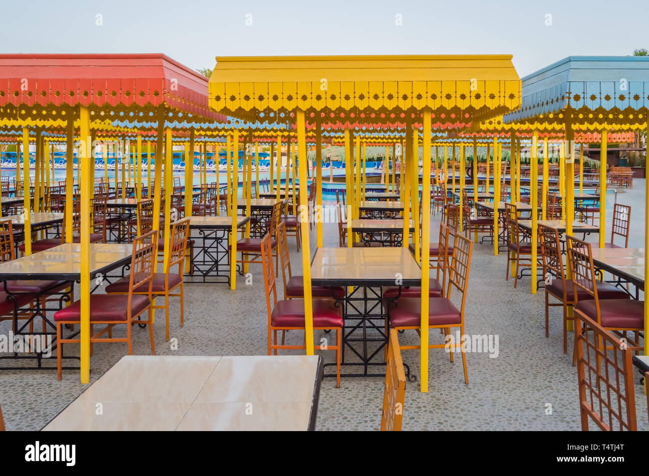 Legno per esterni terrazza ristorante con tavoli con quattro posti a sedere con un piccolo tetto contro il sole. Foto Stock