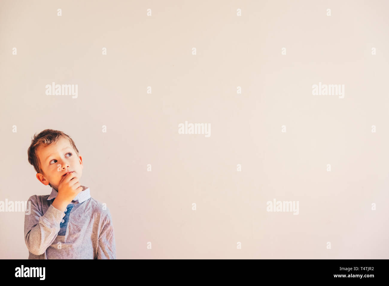 5 anno vecchio ragazzo con molto espressivo gesto premuroso, su sfondo bianco con Copia area di spazio. Foto Stock