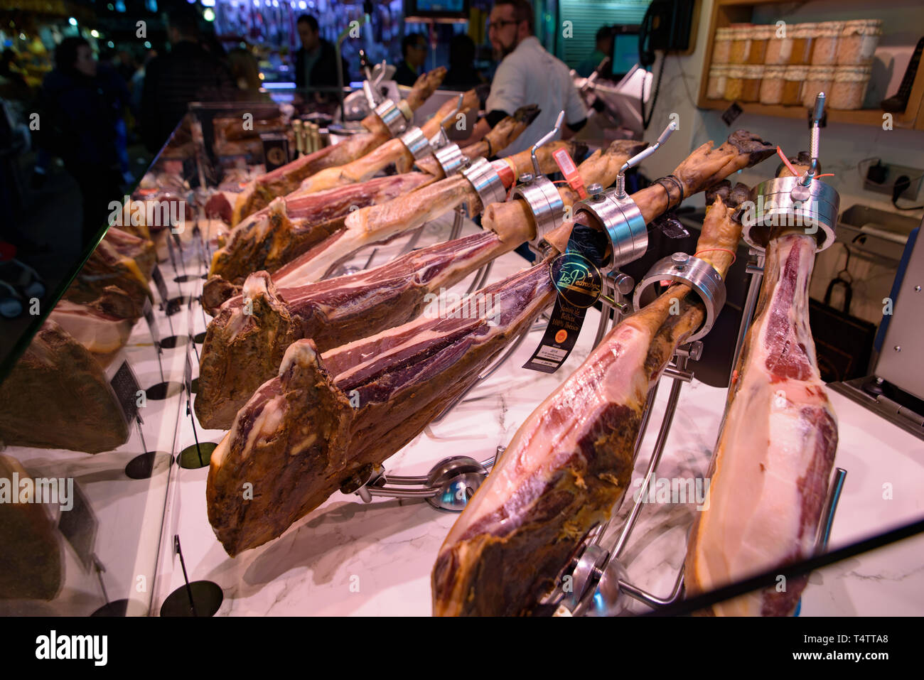 Le bancarelle che vendono jamón serrano, il dry-cured prosciutto spagnolo fatta con i suini di razza iberica, a Barcellona, Spagna Foto Stock