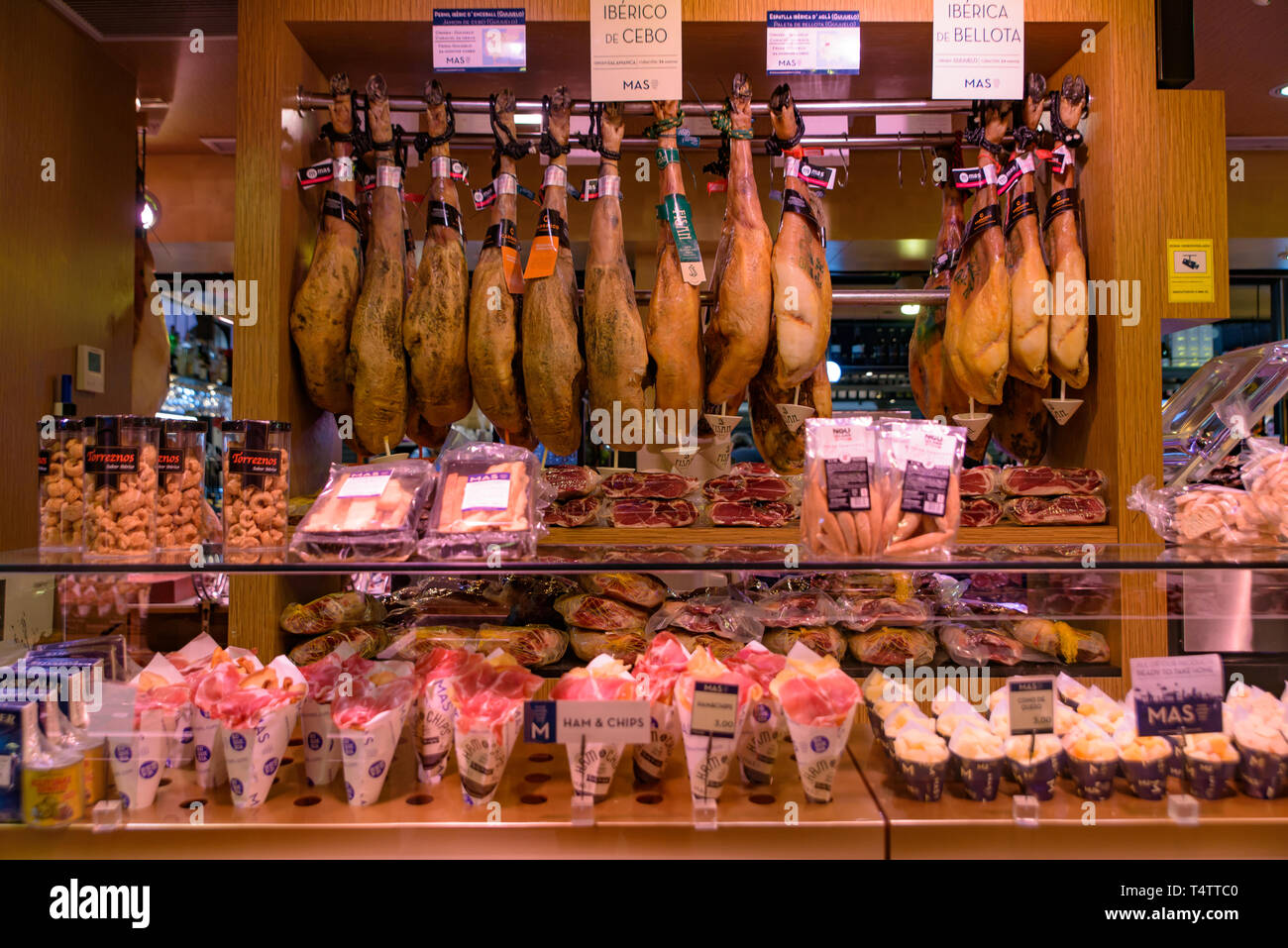 Le bancarelle che vendono jamón serrano, il dry-cured prosciutto spagnolo fatta con i suini di razza iberica, a Barcellona, Spagna Foto Stock
