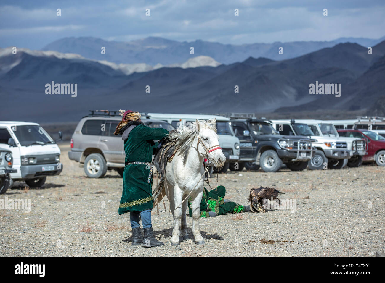 Il bayan Ulgii, Mongolia, 3 ottobre 2015: uomo kazako in tradizionale soprabito e il cappello con il suo cavallo a un parcheggio in natura Foto Stock