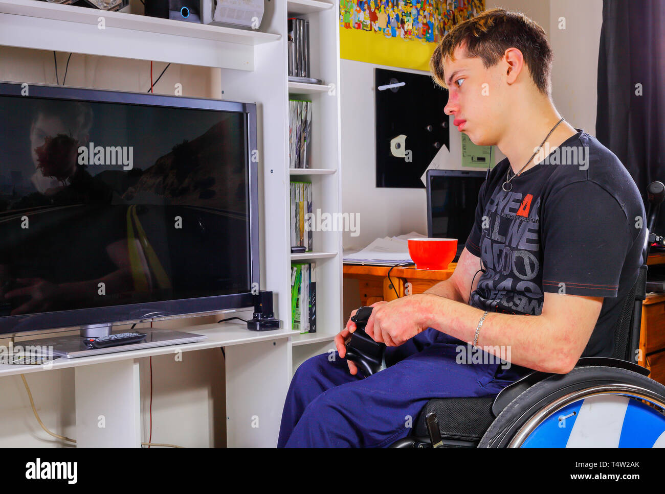 Ragazzo disabile svolge nella sua stanza giochi video Foto Stock