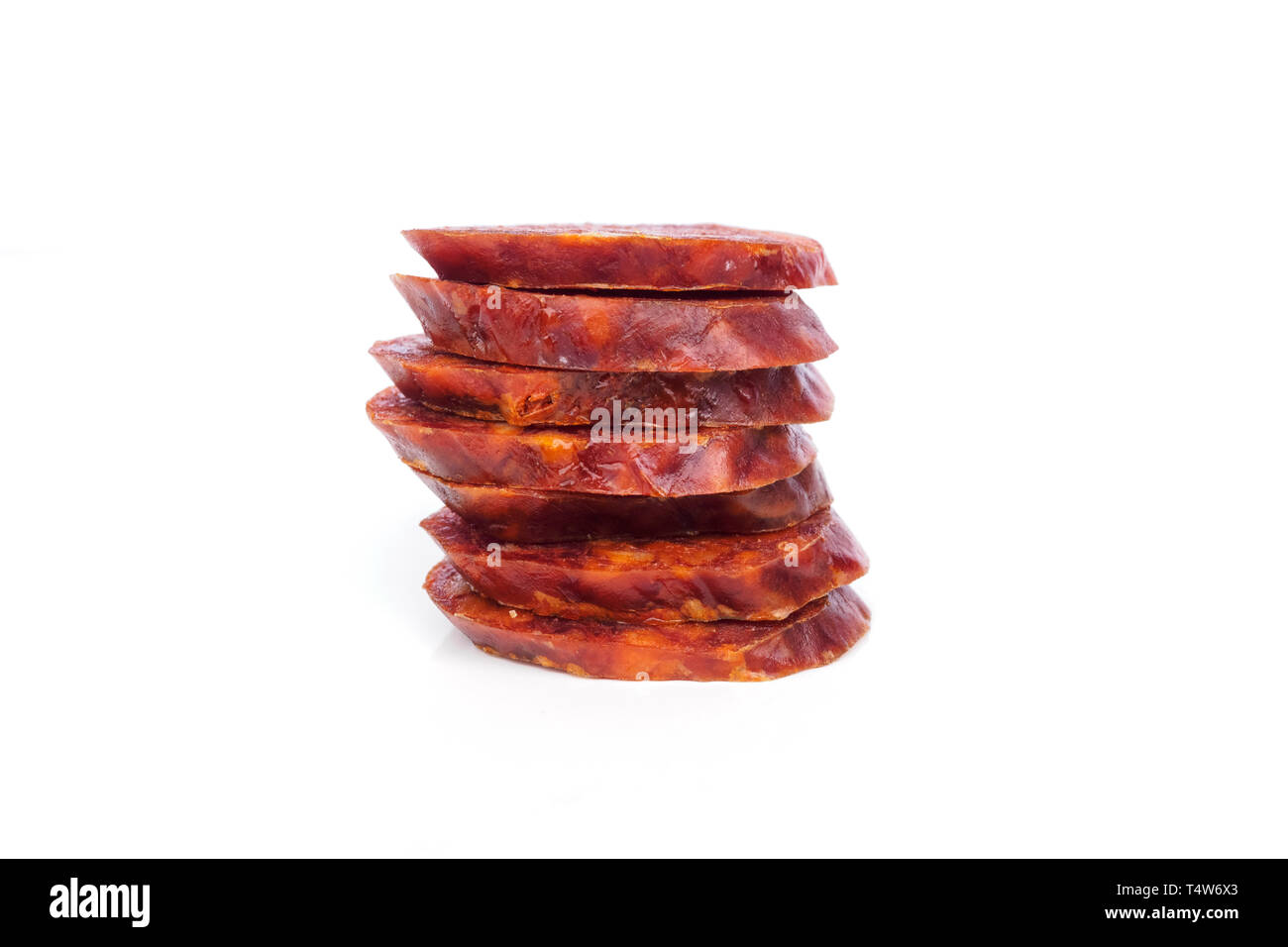Chorizo iberico, il chorizo spagnolo spagnolo ​​or salsiccia tagliata a fette collocati uno sull'altro su un fondo bianco, tipiche tapas spagnole Foto Stock