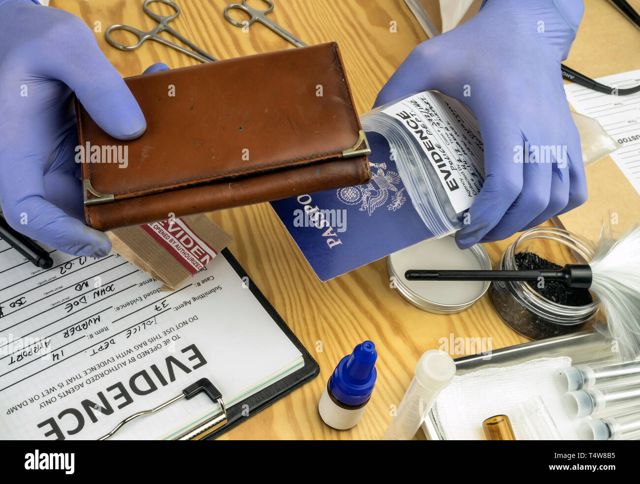Esperto di polizia esaminando passaporto americano e portamonete di una busta di prova nel laboratorio criminalistic, immagine concettuale Foto Stock