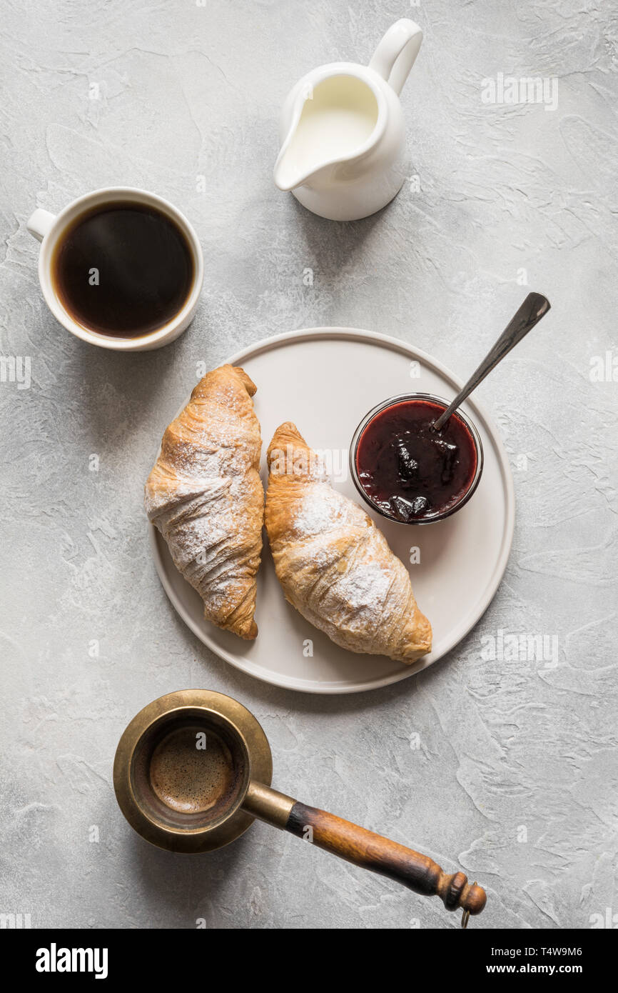 Concetto prima colazione francese. Tazza di caffè e croissant appena sfornati. Vista dall'alto. Foto Stock