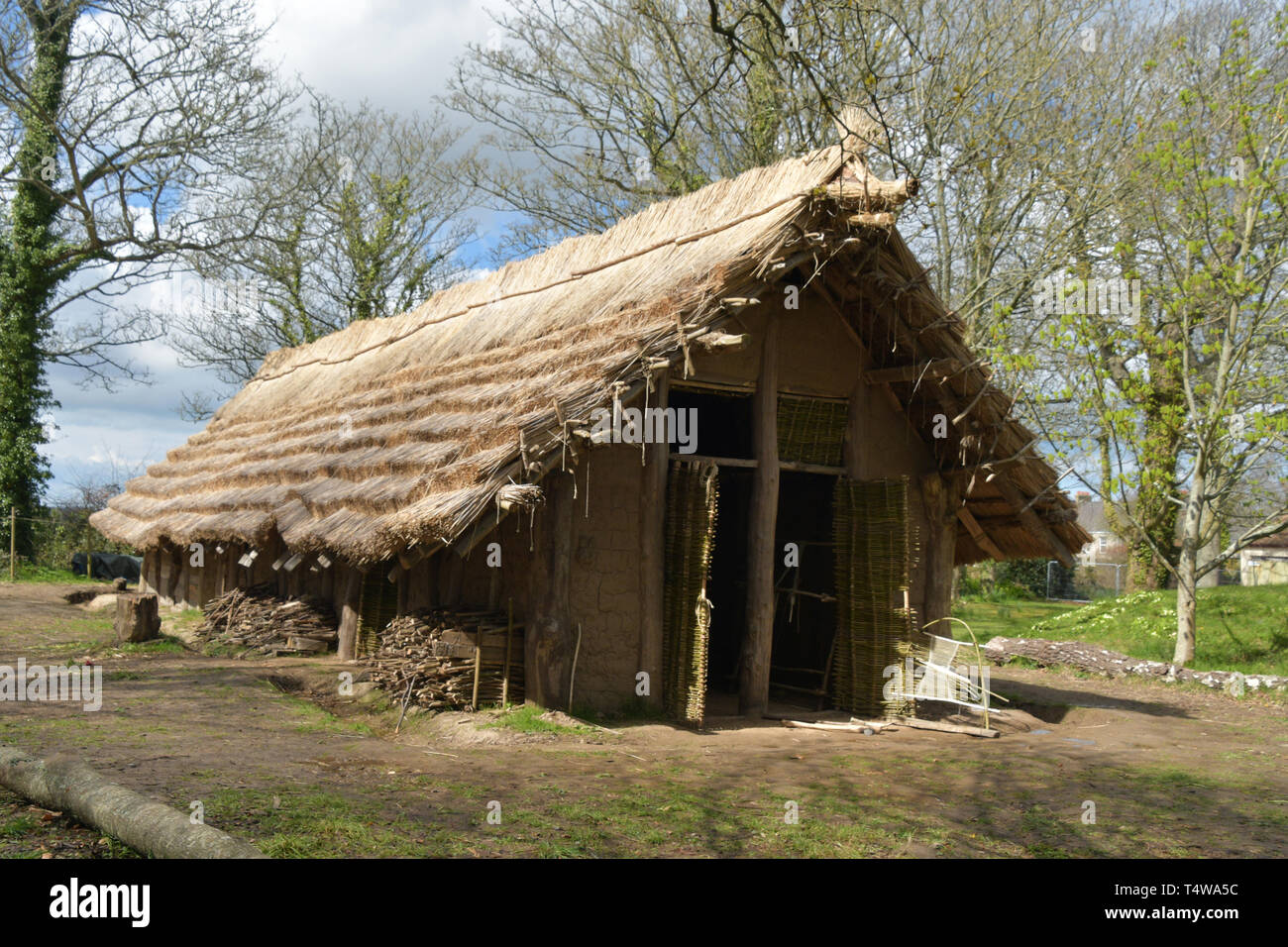 Il neolitico Longhouse presso La Hougue Bie museo è stato costruito utilizzando strumenti antichi e mestieri.Con una lamella tetto di paglia supportato su colonne di legno. Foto Stock