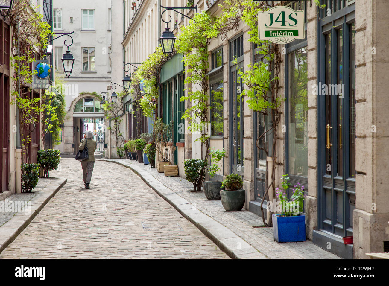 Donna cammina la strada acciottolata, Cour Damoye, vicino Bastiglia, 11th Arrondissement, Parigi, Francia Foto Stock
