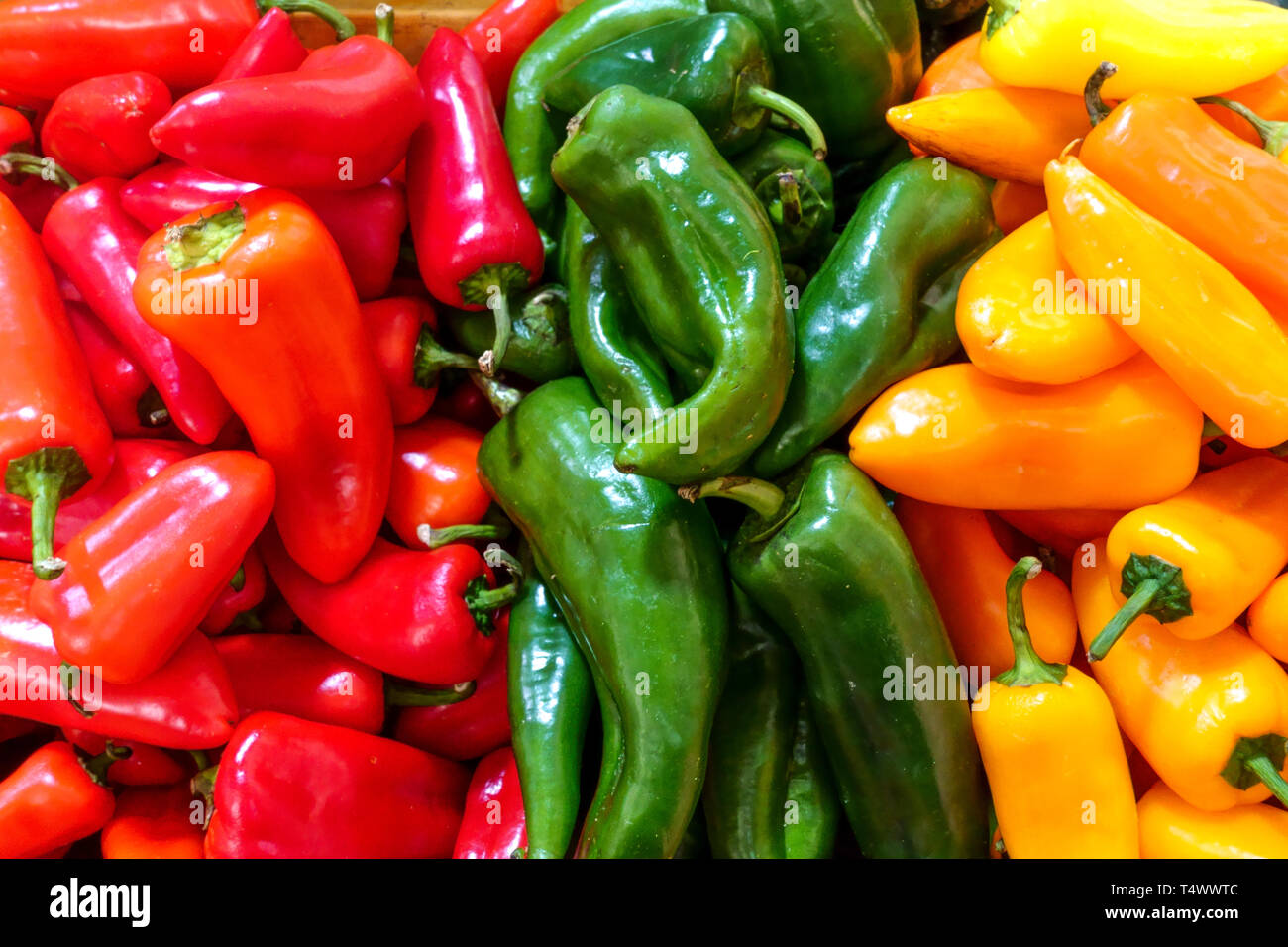 Peperoni colorati, peperoni arancioni verdi rossi al mercato agricolo in Spagna Foto Stock