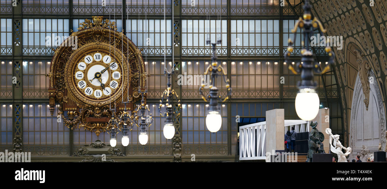 Parigi, Francia - 28 dicembre 2018: storico orologio in oro e lampade di tipo iconico che decorano la sala principale del Museo di Orsay, un ex 1900 stazione ferroviaria Foto Stock
