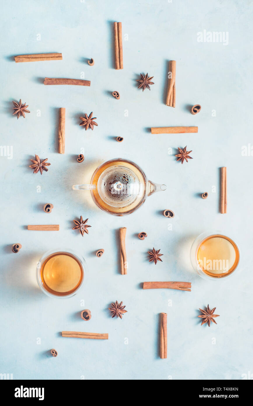 La cannella e anice pattern con teiera e tazze di tè su un bianco sullo sfondo di legno con copia spazio. Bevanda calda creative laici piana. Foto Stock