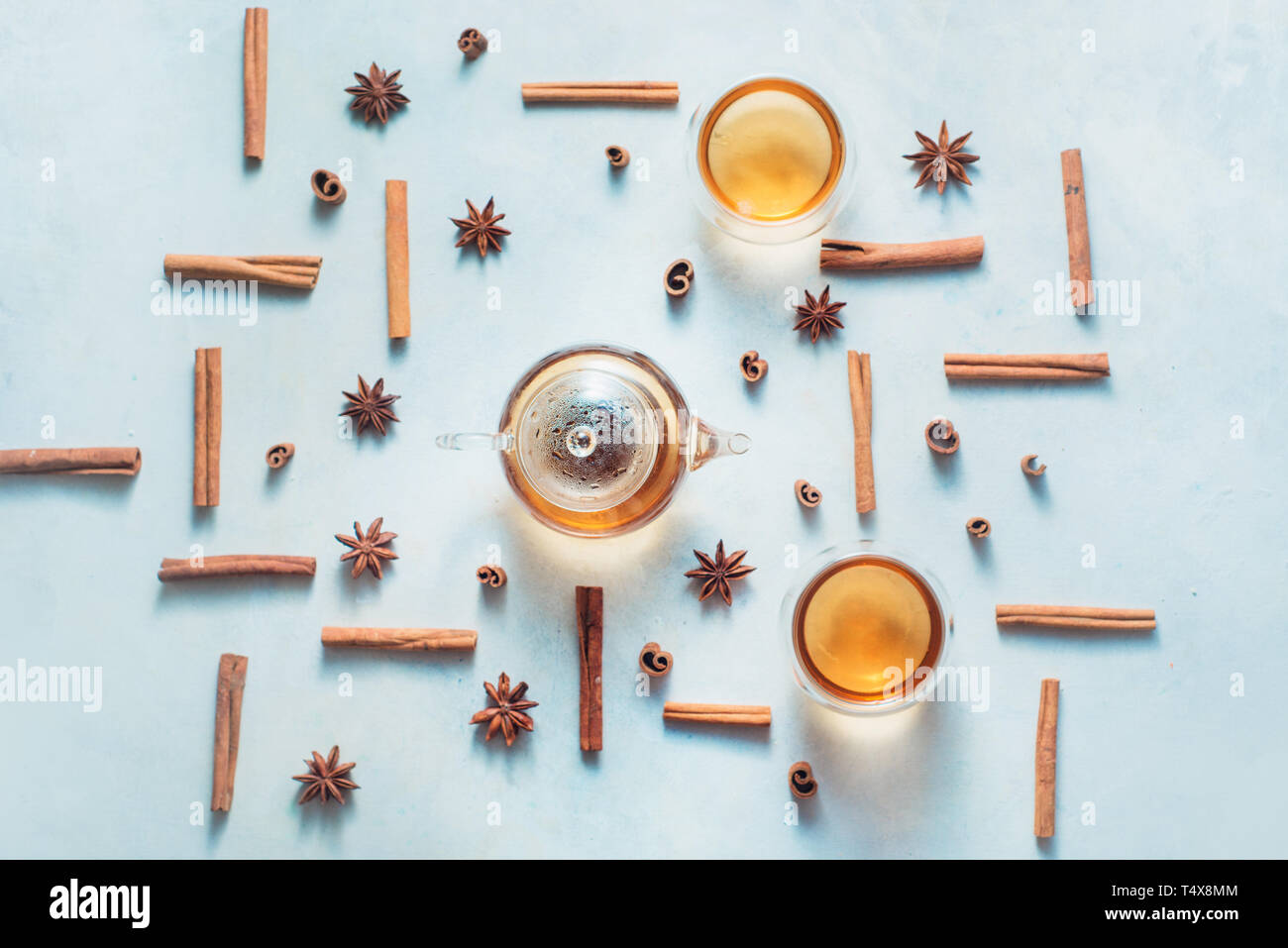 La cannella e anice pattern con teiera e tazze di tè su un bianco sullo sfondo di legno con copia spazio. Bevanda calda creative laici piana. Foto Stock