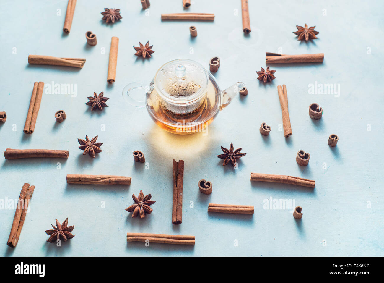 Creative disposizione tè alla cannella, anice stelle, teiera e tazze di tè su uno sfondo bianco con copia spazio. Bevanda calda creative testata. Foto Stock