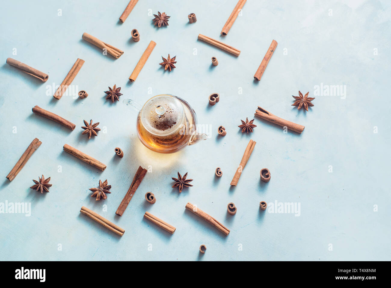 Creative disposizione tè alla cannella, anice stelle, teiera e tazze di tè su uno sfondo bianco con copia spazio. Bevanda calda creative testata. Foto Stock
