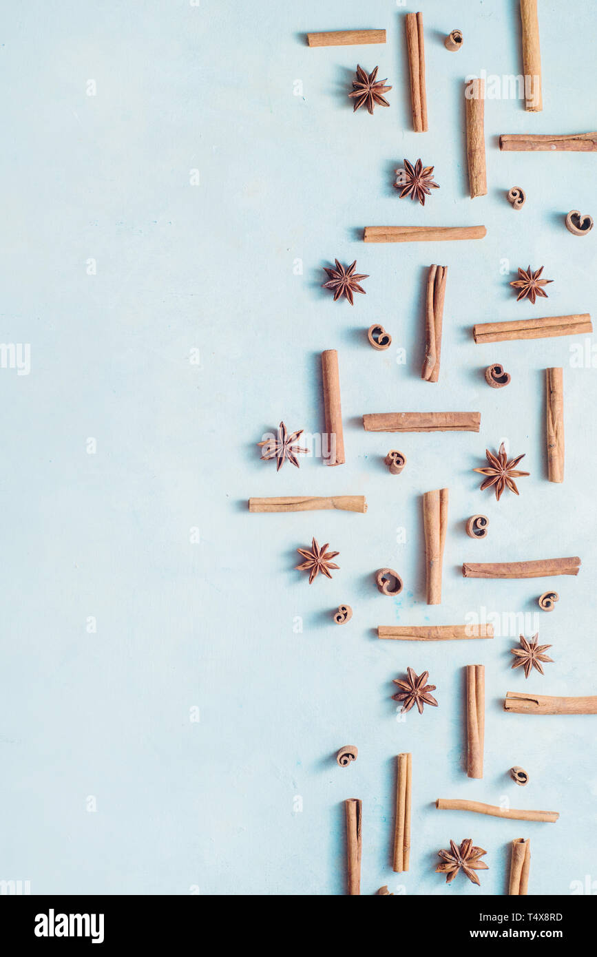 La cannella e anice stella su un bianco sullo sfondo di legno con copia spazio. Cucina creativa laici piatto con spezie. Foto Stock