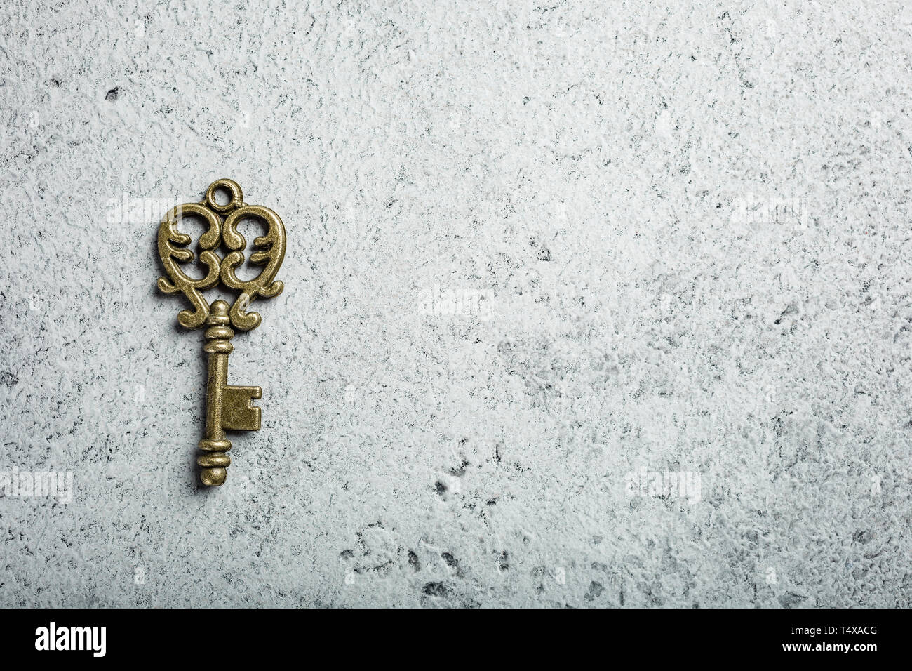 Vecchia chiave sul vecchio cemento grigio Sfondo. Foto Stock