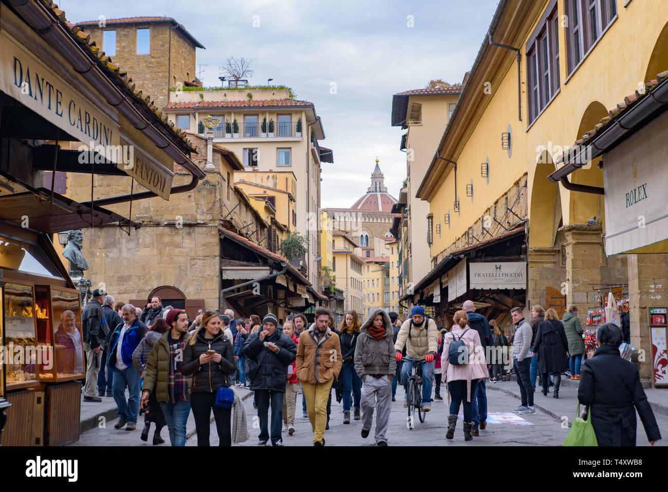La gente che camminava sul Ponte Vecchio, un medievale ponte in pietra con negozi su di esso, Firenze, Italia Foto Stock
