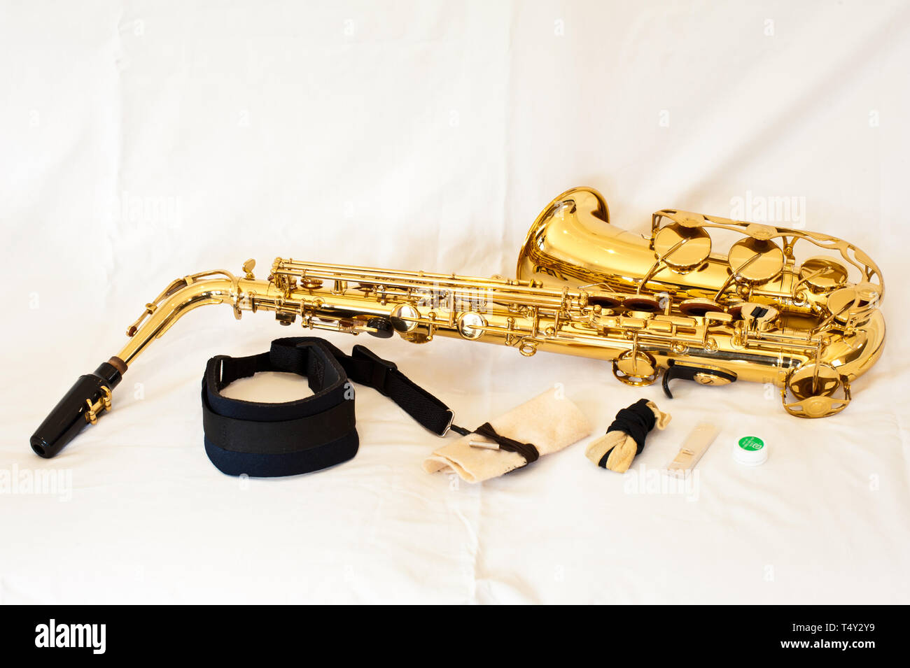 Un oro / ottone alto sassofono su sfondo bianco con tasti in madreperla - stabiliti con gli accessori inclusi cinturino, aspirapolvere, reed e grasso di sughero Foto Stock