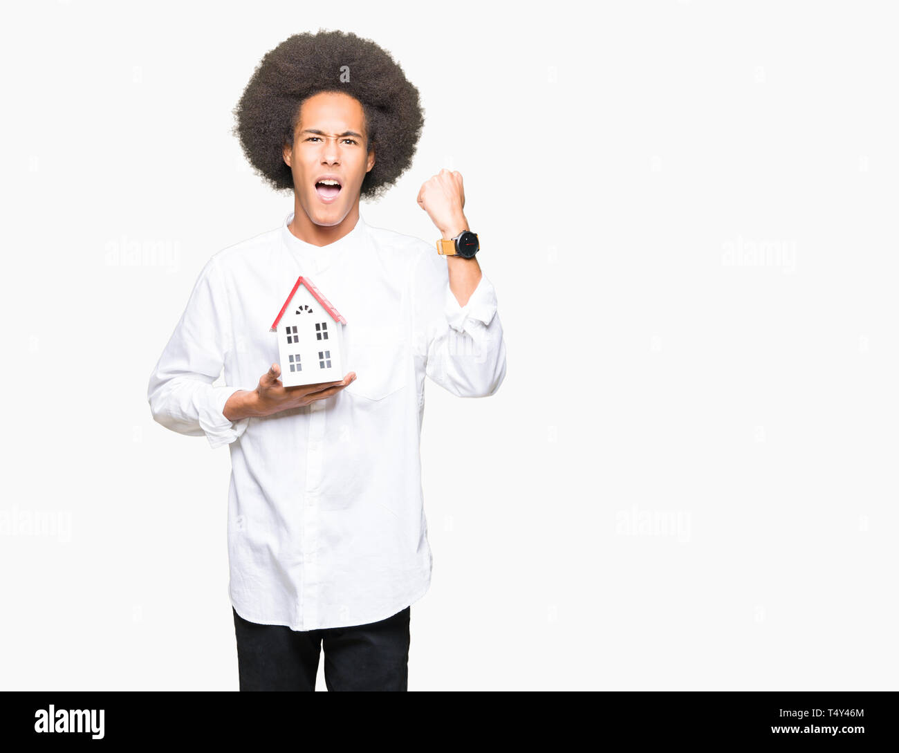 Giovane americano africano uomo con capelli afro holding house irritato e frustrato grida con rabbia, crazy e urla con la mano alzata, concetto di rabbia Foto Stock