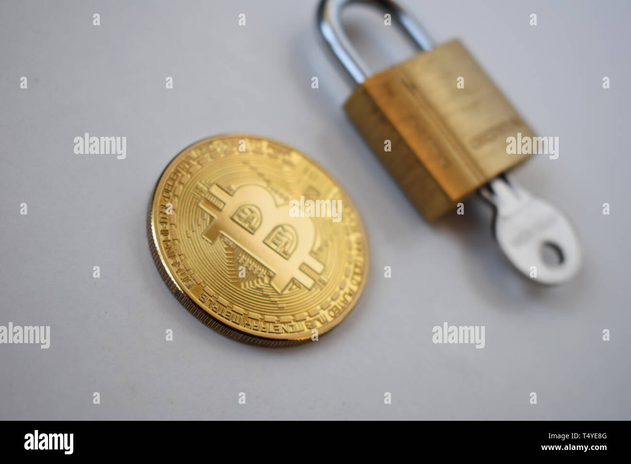 Bitcoin concetto di sicurezza. Moneta in oro con lucchetto su uno sfondo luminoso.. Foto Stock
