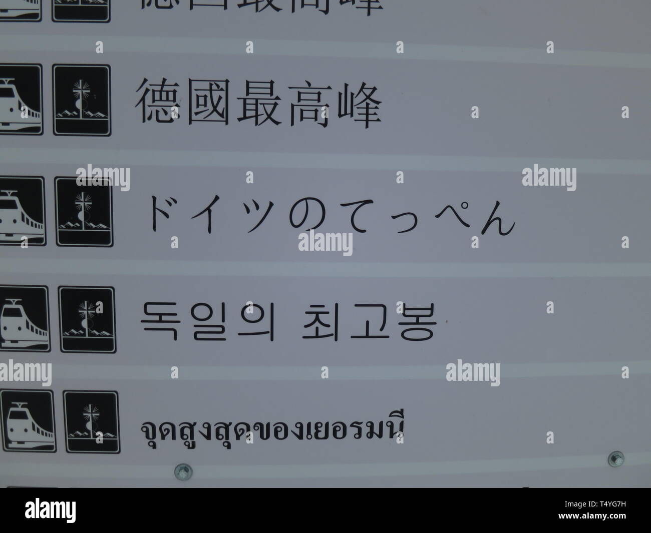 Wegweiser zur Zugspitz-Bahn in nicht lateinischen Buchstaben. Foto Stock