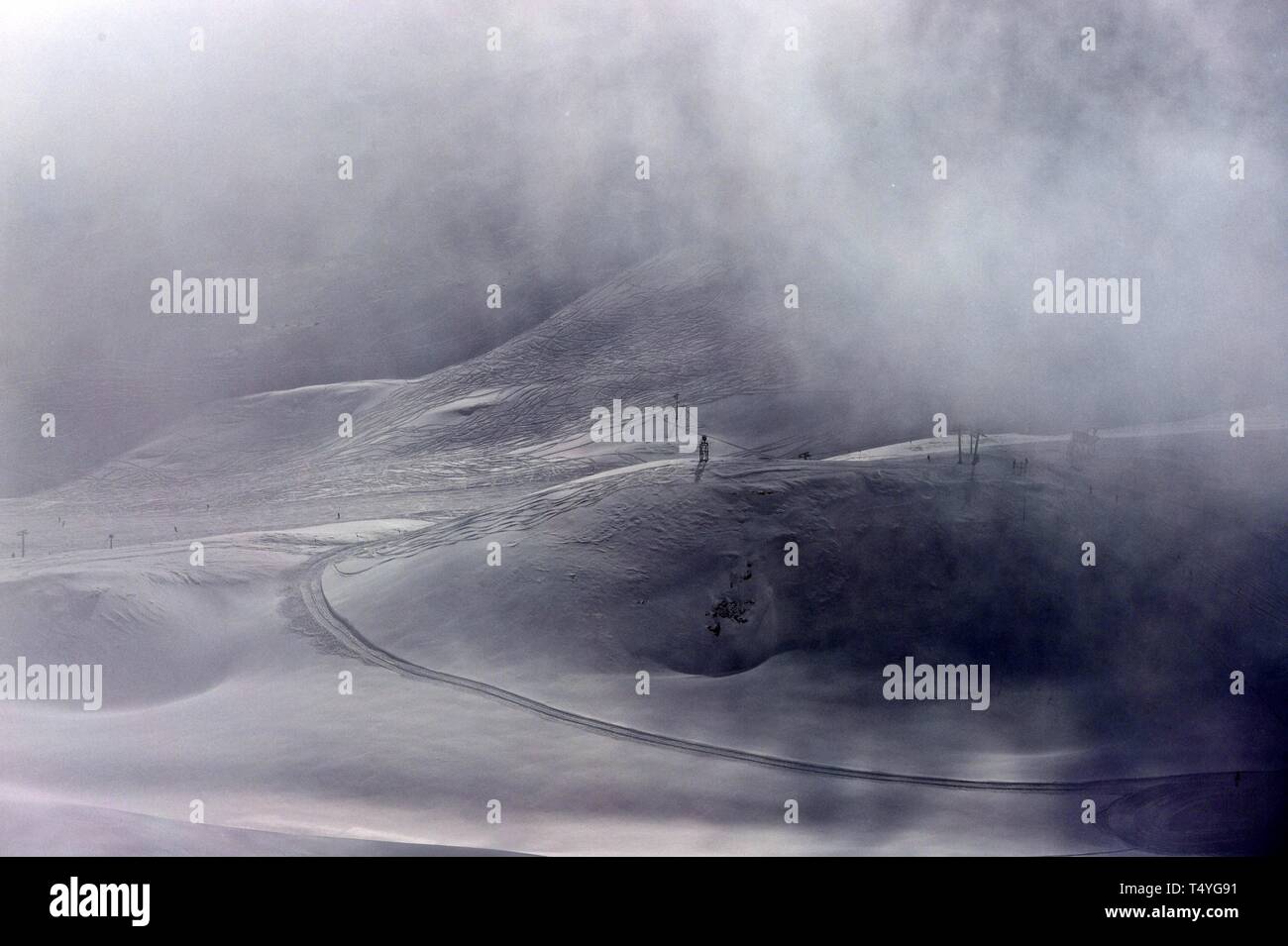 Zugspitze: Im Nebel erkennt man die Stützen eines lifts und schemenhaft ein paar Skiläufer. Foto Stock