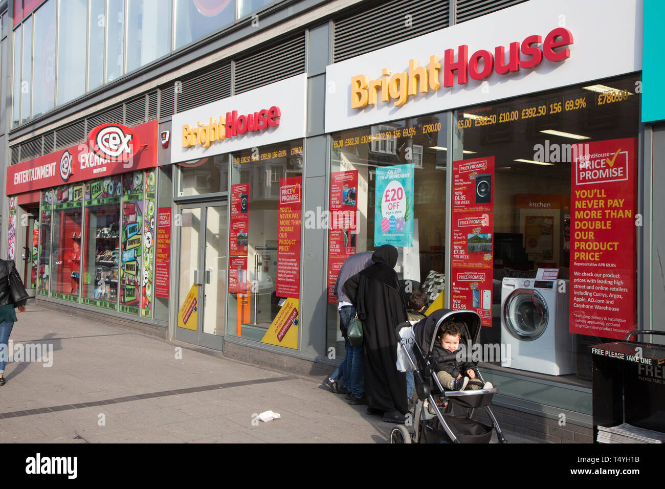 I pedoni a camminare lungo i negozi di High Road, Wembley Foto Stock