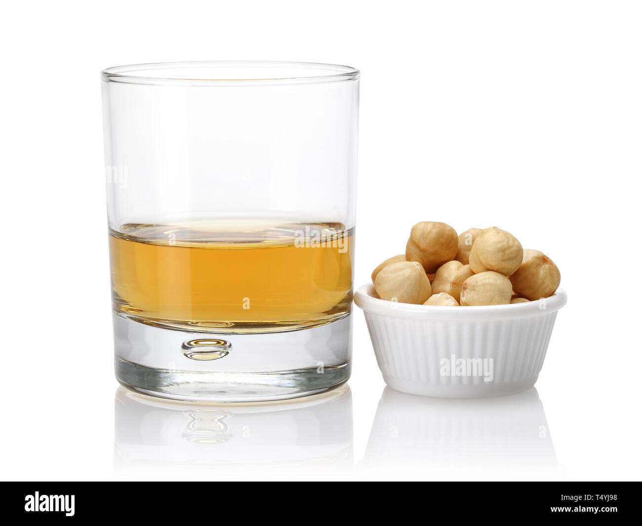 Un bicchiere di whiskey e nocciole in una ciotola isolato su sfondo bianco Foto Stock