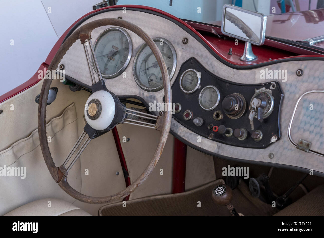 Il cruscotto di un classico vintage open top sport auto con volante in legno con guida a sinistra. Foto Stock