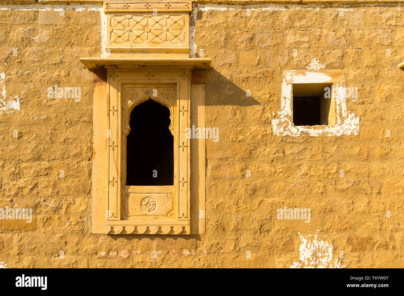 Tradizionale finestra ad arco in pietra arenaria parete in kumbalgarh Jaisalmer, Rajasthan, India. Questa famosa destinazione turistica è detto di essere ossessionato Foto Stock