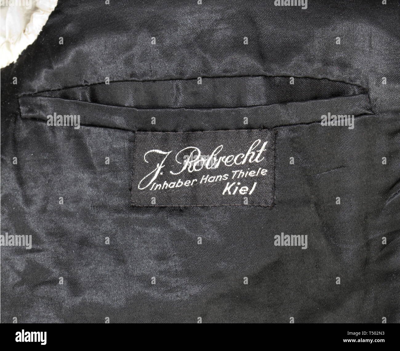 Günther Prien, comandante della 'U-47' - un pasticcio giacca e certificazione di personale. Una giacca blu scuro panno di cotone con due righe ciascuno di quattro gilt pulsanti ancoraggio (13 mm) con l'etichetta " Extra Fein", con catena di chiusura, in bianco e nero Seta camicia interna. Corretta senza ritegno epaulette resp. schede di spalla, manicotto badge in rango di Kapitänleutnant, ricamati a mano con insegne e loop di ordini per la croce di ferro di prima classe del 1939, campo Chiusura degli ordini e U-Boat badge di guerra. Con due etichette personalizzate della ditta "J. Robrecht, Inhaber Hans Thiele, Kiel','interno con ', Editorial-Use-solo Foto Stock