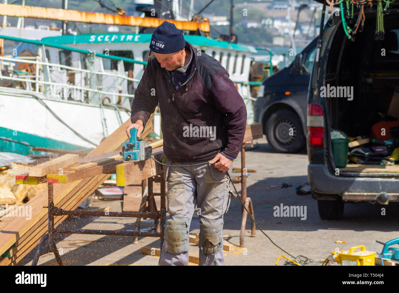 Carpenter shipwright utilizzando un piano elettrico su una tavola di legno di teak Foto Stock