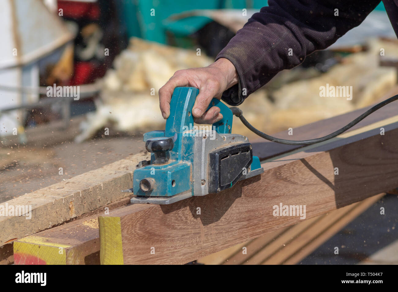 Carpenter shipwright utilizzando un piano elettrico su una tavola di legno di teak Foto Stock
