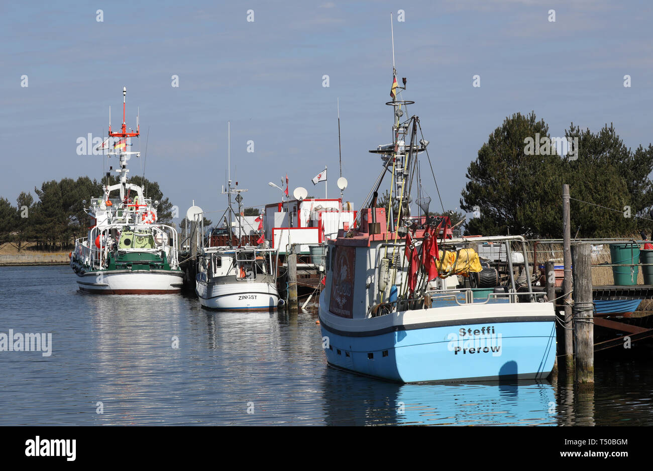 Prerow, Germania. Xvii Apr, 2019. Barche da pesca nel porto di emergenza Darßer Ort in Kerzone del Parco Nazionale di Vorpommersche Boddenlandschaft, sulla sinistra il salvataggio cruiser 'Vormann Jantzen' della stazione della Società tedesca per il salvataggio dei naufraghi DGzRS. Credito: Bernd Wüstneck/dpa-Zentralbild/ZB/dpa/Alamy Live News Foto Stock