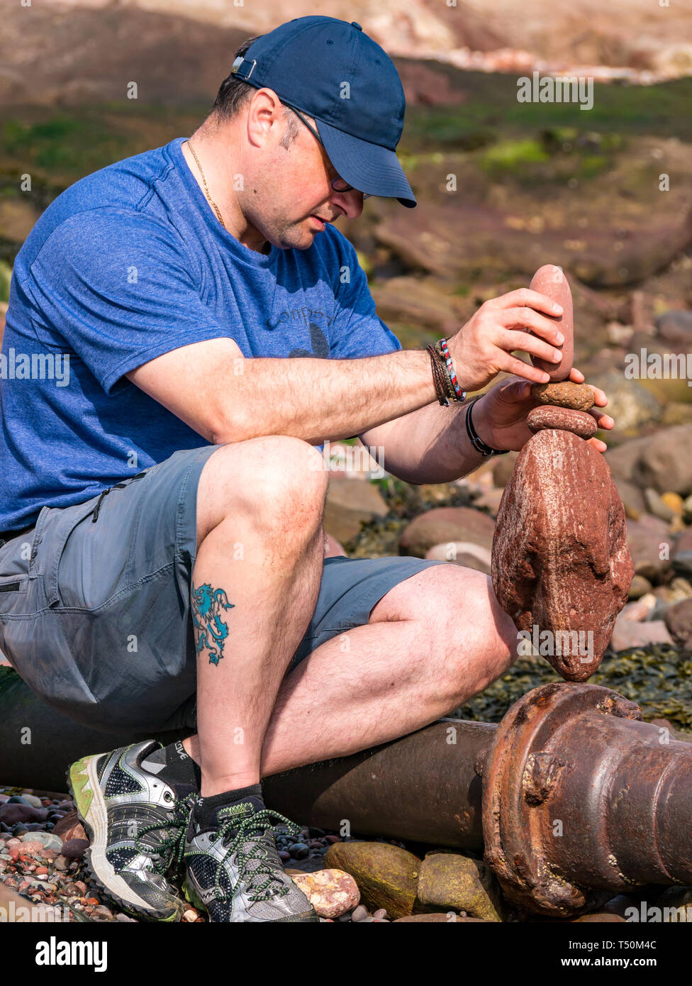 Dunbar, East Lothian, Scozia, Regno Unito, 20 aprile 2019. Unione di pietra campionato di impilamento: Dave amore, da Edimburgo, pietre di bilanciamento a Eye Cave Beach Foto Stock