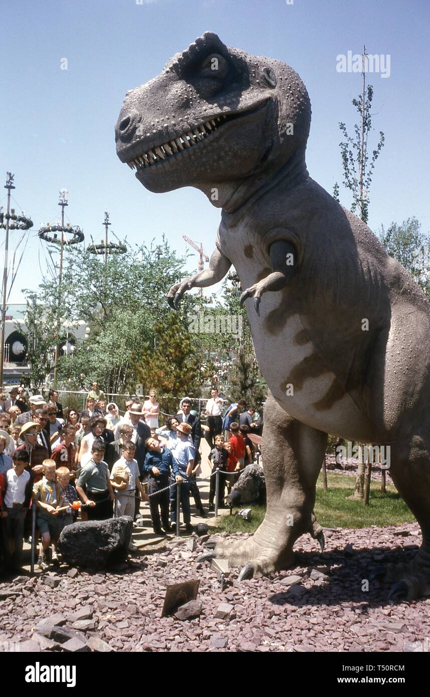 Una folla di persone in una giornata di sole, visualizzazione di un lifesize, vetroresina Tyrannosaurus Rex al Dinoland presentano, Sinclair Pavilion, alla fiera mondiale di New York, Flushing Meadows Park, Queens, a New York, maggio, 1964. () Foto Stock