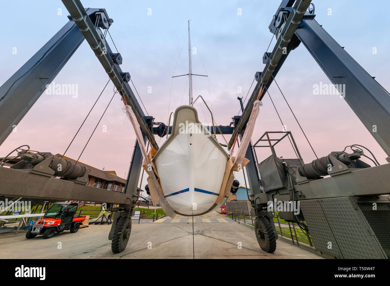 Sailing yacht in un paranco in un cantiere in attesa di essere avviato Foto Stock