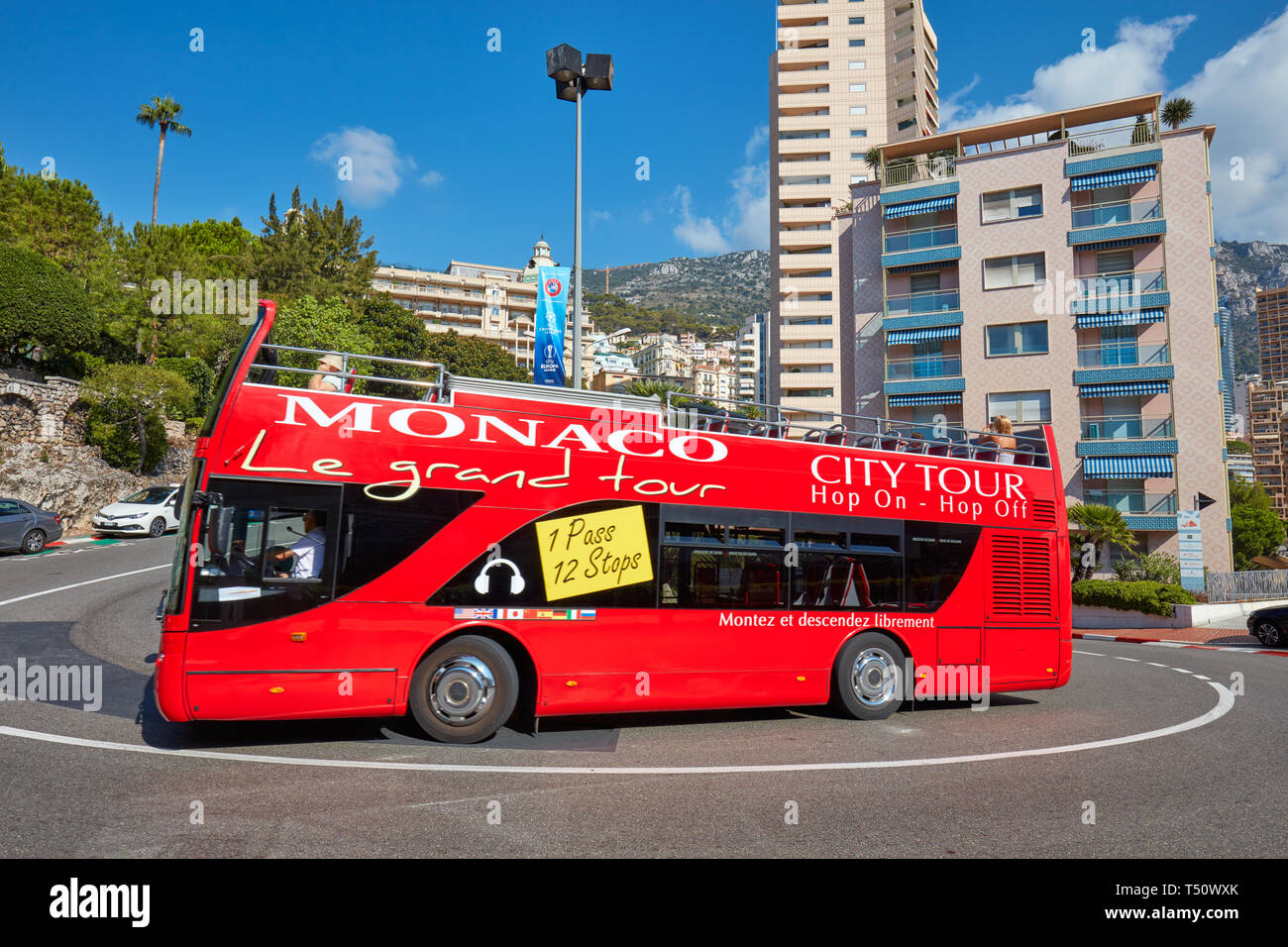 MONTE CARLO, Monaco - Agosto 21, 2016: Monte Carlo street la curva con la formula uno rosso e bianco segni e Monaco red bus turistico in una soleggiata estate d Foto Stock