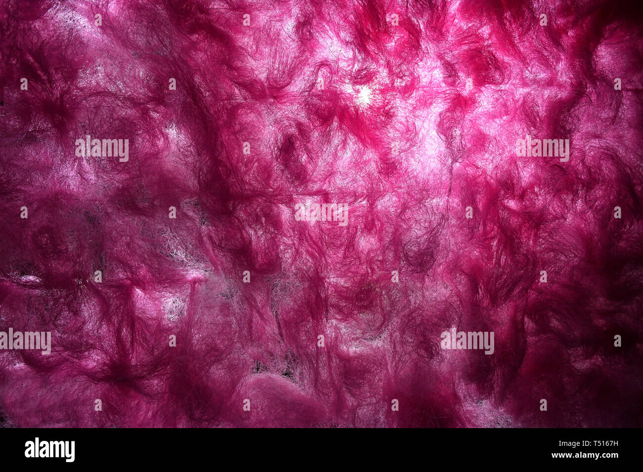 Rosa sfondo astratto di progettare con la luce attraverso la rottura di fibre tessili di lana di cotone o di isolamento sintetico. Full frame closeup con tema d Foto Stock
