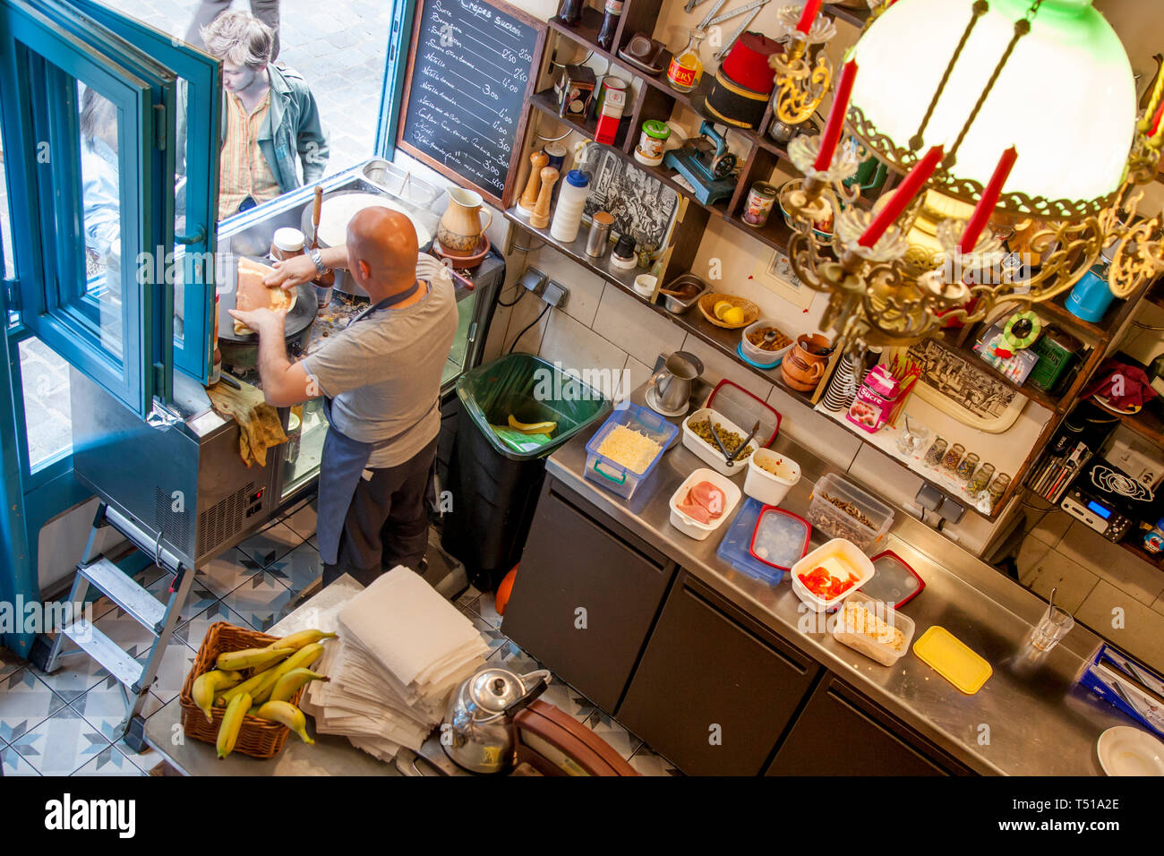 Uomo che fa le crepes per i turisti nel suo Creperia, Marais, Parigi, Francia Foto Stock