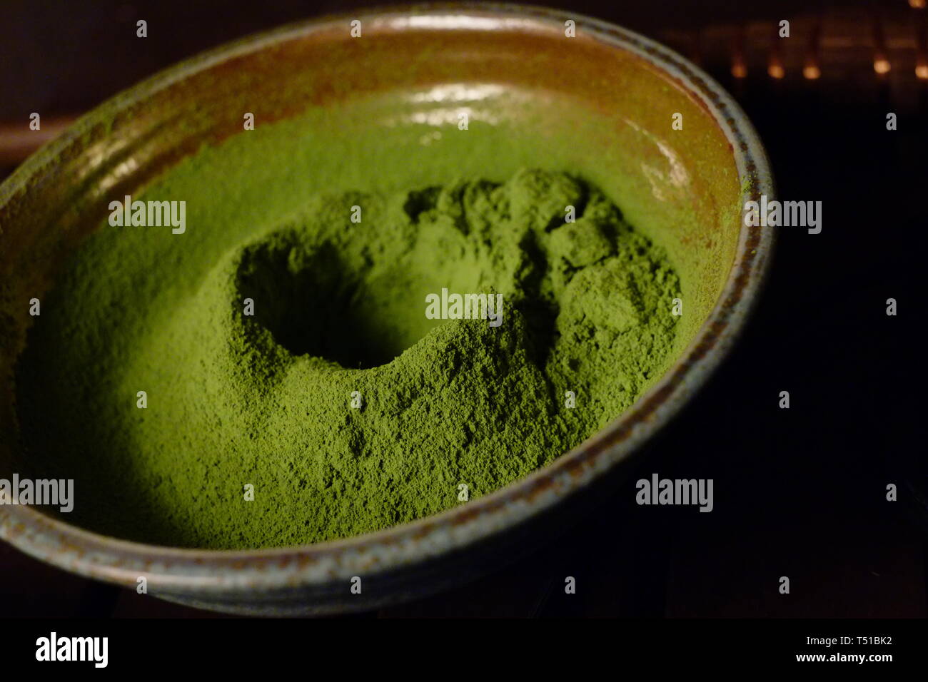 Matcha giapponese in polvere di tè verde in una ciotola. Il tè, che viene utilizzato nella cerimonia del tè giapponese, è noto per le sue proprietà di salute e di sapore amaro. Foto Stock