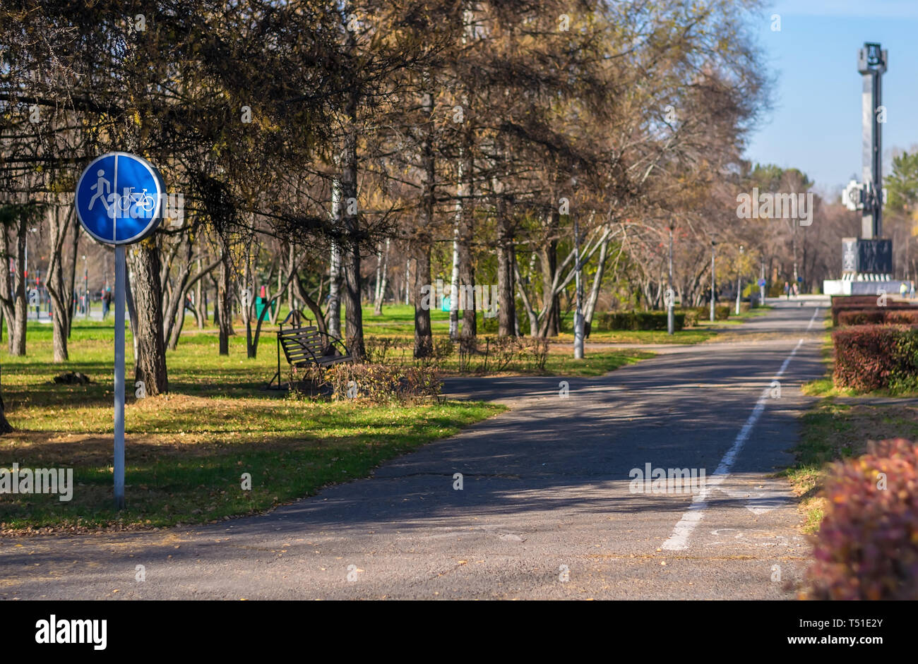 Il parco della città per camminare con panchine e cartello stradale di pedoni / percorsi per bicicletta Foto Stock
