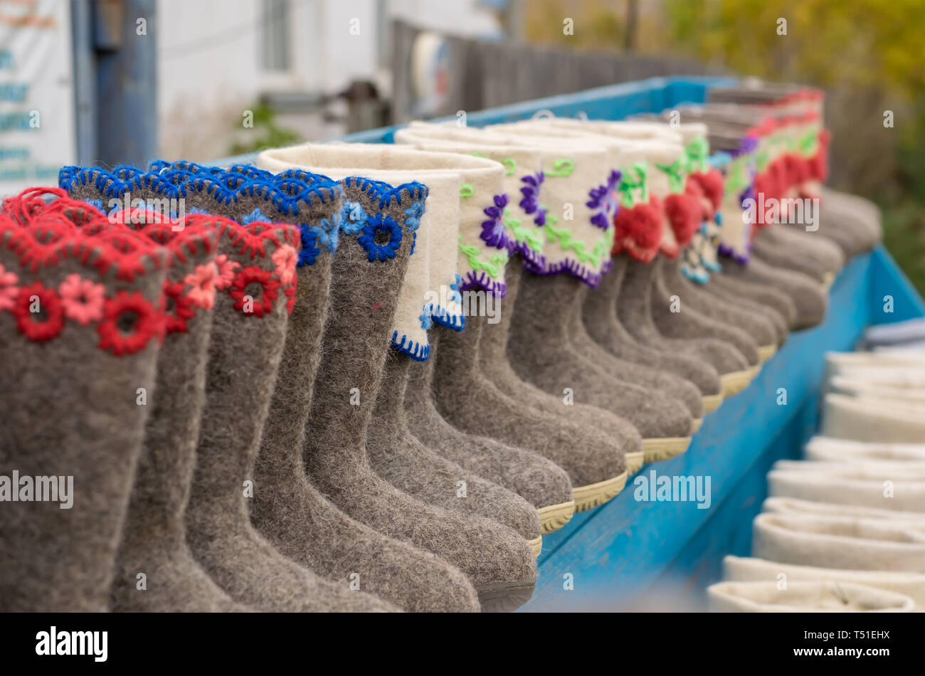 Varie pantofole, scarpe, stivali realizzati in lana di pecora sono in vendita presso il contatore del villaggio Foto Stock