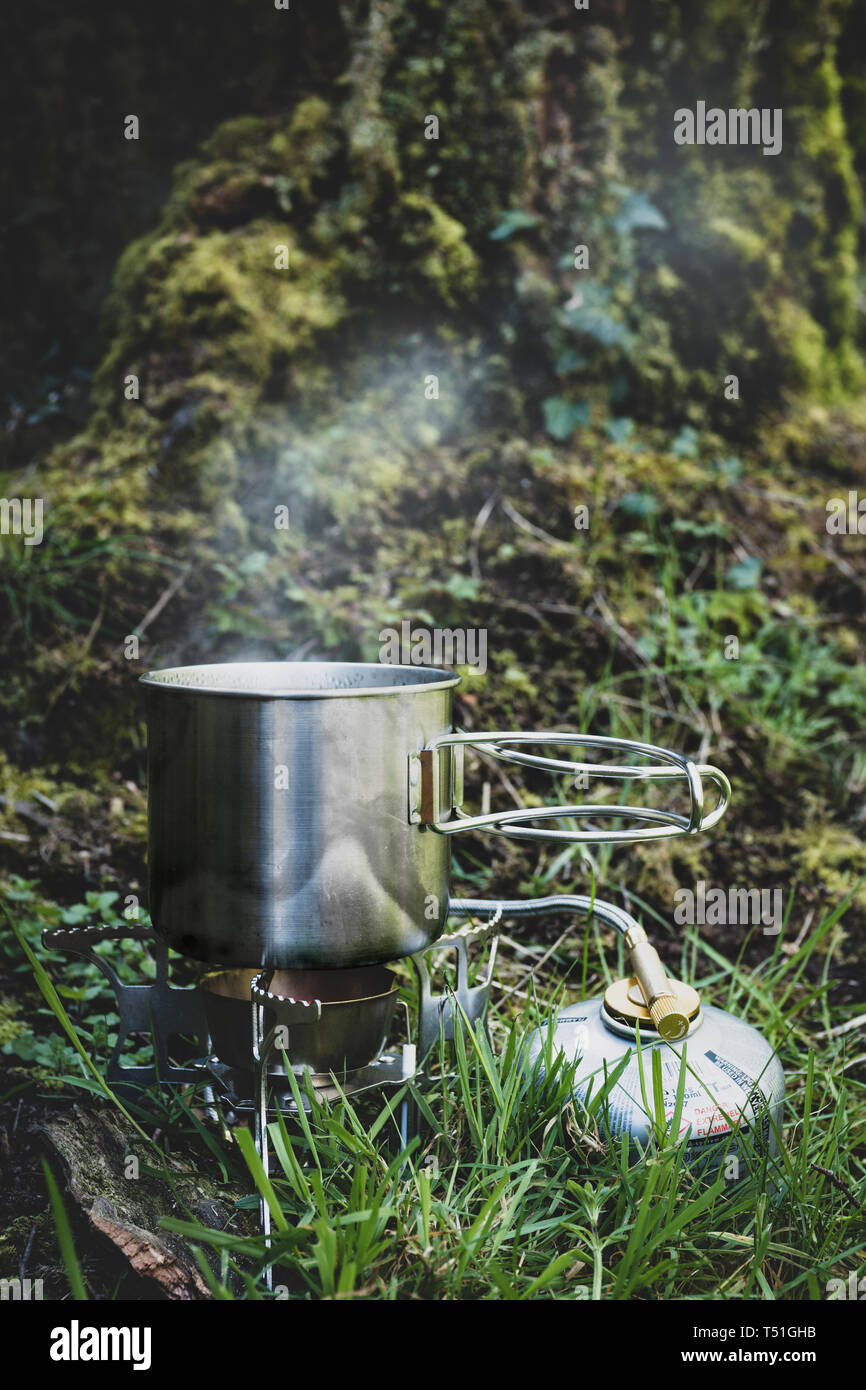 Acciaio inossidabile camp mug su un fornello a gas. Foto Stock