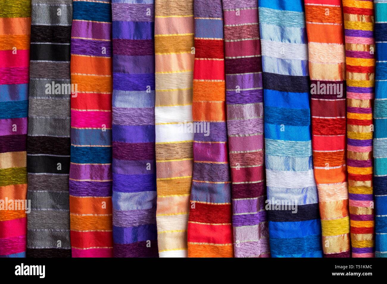 A strisce colorate panni per la vendita presso la bancarella di strada, Essaouira, Marocco Foto Stock