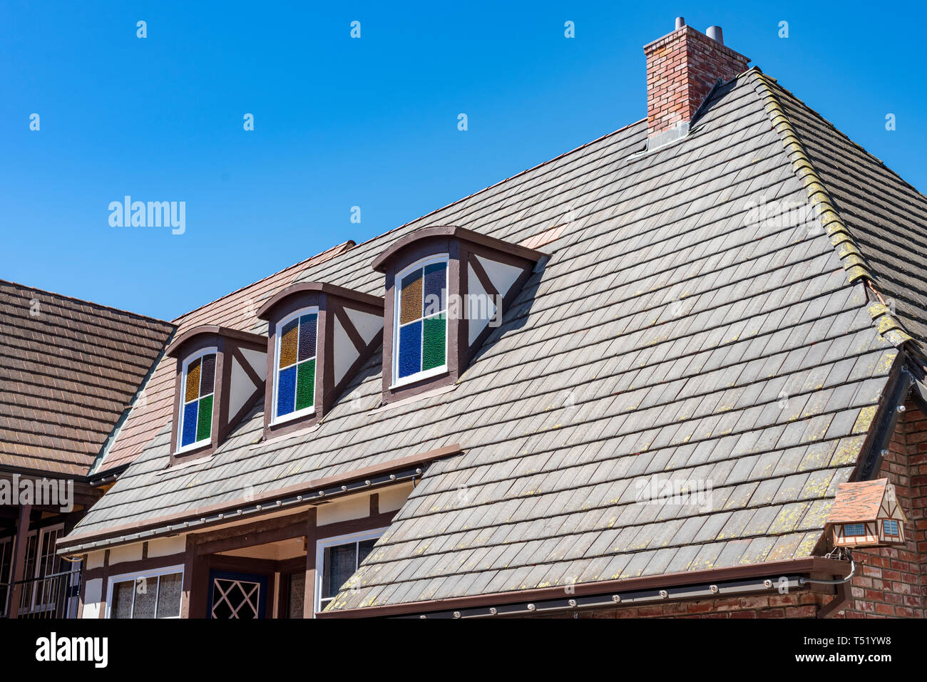 Attico colorati windows che sporgono dal tetto sotto un cielo blu. Foto Stock