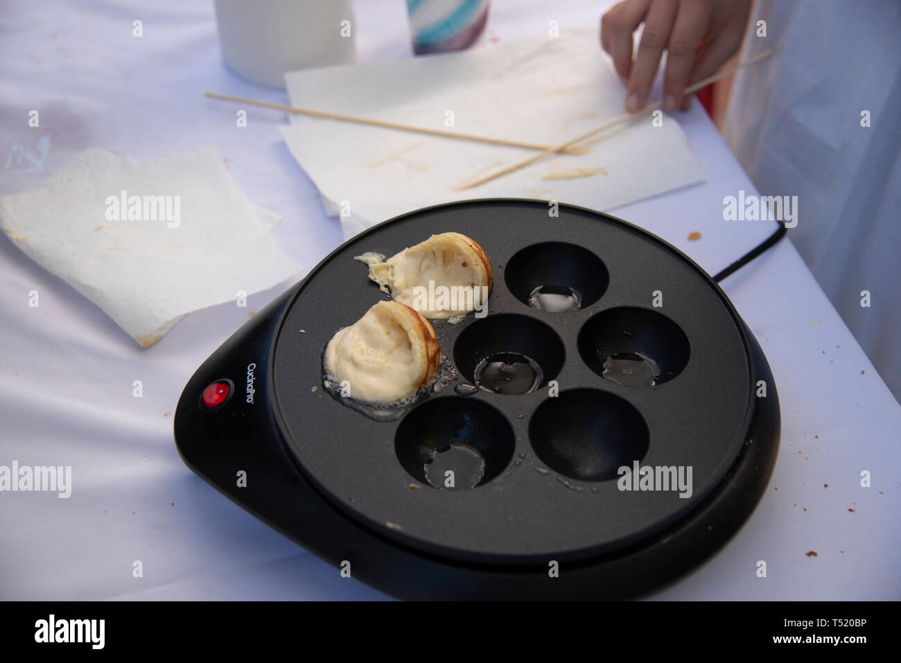 Le immagini che mostrano come cuocere Aebleskiver. La coppa con la cottura di pasta sulla tavola a giorni danese evento. Foto Stock